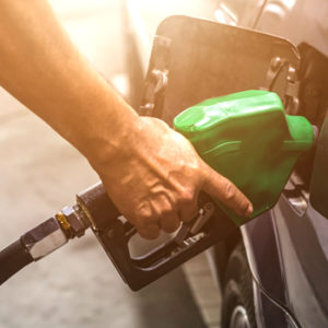 man filling car with gasoline